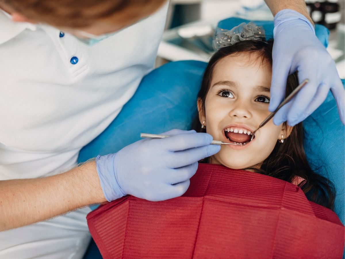 Smiling little girl during a gentle pediatric dental checkup at OraCore Dental in Odenton, MD
