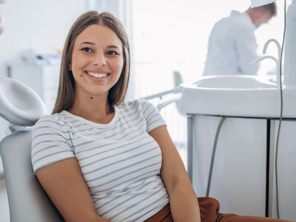 Smiling patient sitting comfortably in a dental chair after a positive dental care visit at a modern dental office