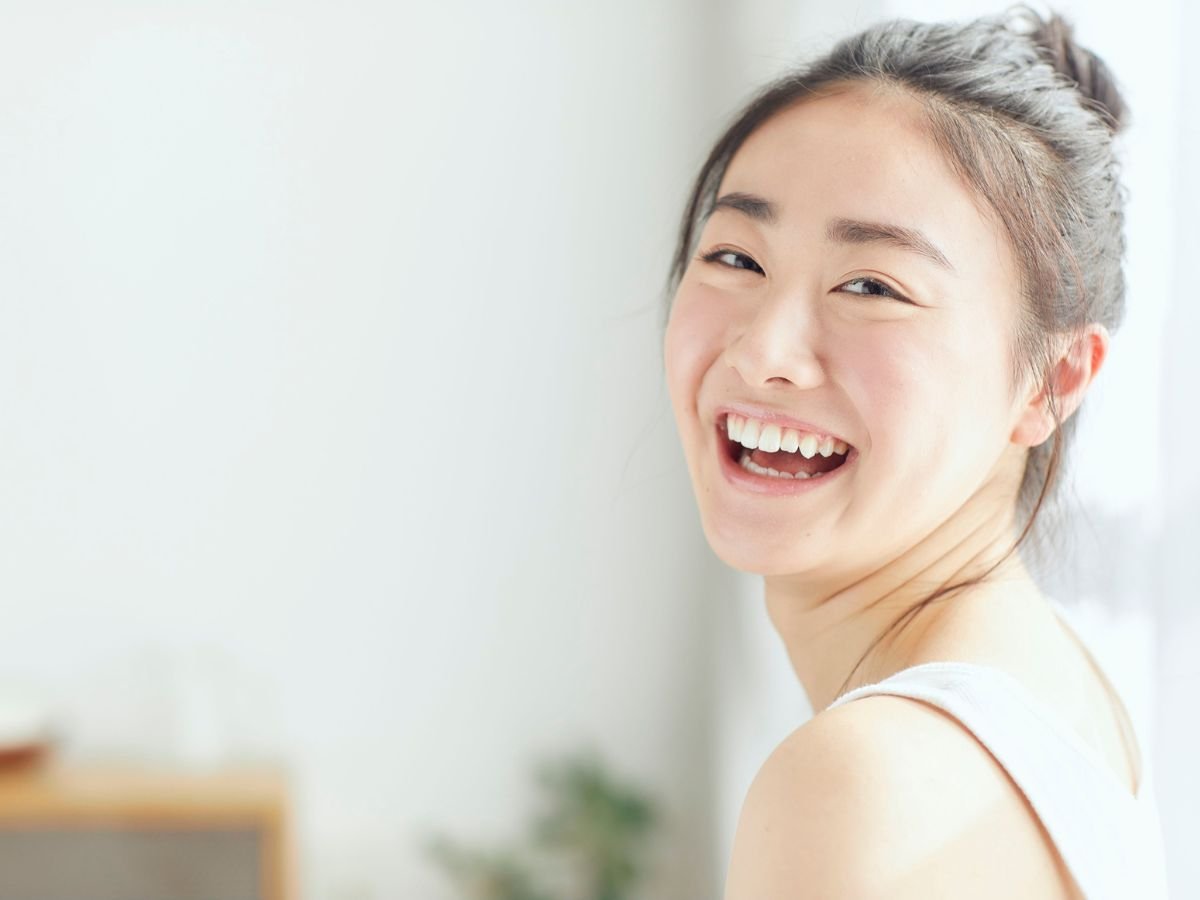 A happy female patient smiling after cosmetic dental treatment at OraCore Dental in Odenton, MD, demonstrating advanced cosmetic dentistry solutions that enhance teeth appearance and overall dental health.