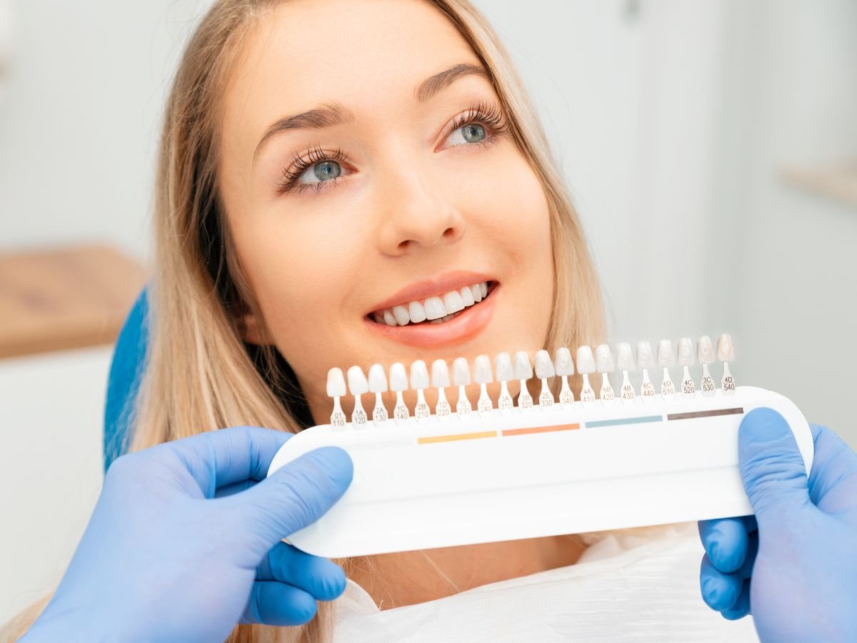 A dentist at OraCore Dental in Odenton, MD consulting with a patient while showing porcelain veneer samples, representing personalized cosmetic dentistry, smile makeovers, and aesthetic dental treatment planning.